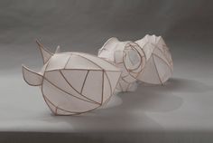 three sculptures made out of paper sitting on top of a table