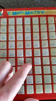 a hand is pressing the numbers on a red keyboard