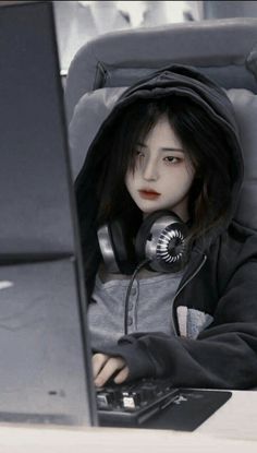 a doll with headphones sitting in front of a laptop