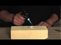 a man is working on some kind of concrete block with a small tool in his hand