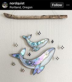 two dolphins are hanging on the wall next to a stick and some stardusts