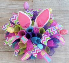 a close up of a bunch of hair accessories on a wooden surface with an easter egg in the background