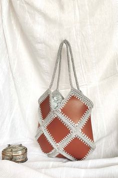 %100 hand made small size brown baklava diagonal shape crochet bag with vegan leather and chain hanger. The bag made with high quality yarns and leather This special bag is lined. Perfect for special days, city adventures and shopping etc.  This crochet bag is the perfect accessory for your spring and summer. Summer is so close and the sun is shining everywhere, it's time for summer fashion :) This bag can be used for anything. A nice gift idea  Measures: Height: 30 cm, Width : 30 cm, Handles : 50 cm Height: 11,80 inch, Width: 11,80 cm,  Handles : 19,70 cm Materials:  Paper yarn and vegan leather Please feel free to contact with us if you have any question. Brown Leather Crochet Bag With Handles, Daily Use Brown Crochet Bag With Woven Leather, Brown Woven Leather Crochet Bag For Daily Use, Brown Leather Woven Crochet Bag For Daily Use, Brown Crochet Tote Shoulder Bag, Brown Rectangular Crochet Bag With Granny Square, Brown Square Crochet Bag With Granny Square, Brown Square Crochet Bag With Granny Square Design, Brown Crochet Bag With Granny Square Design