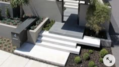 a modern house with concrete steps leading up to the front door