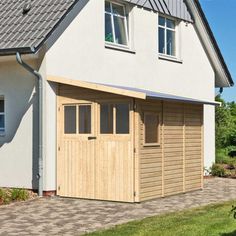 a large white house with a wooden garage