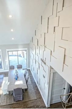 Modern dining area with a large table, grey chairs, unique wall panel design, and glass doors leading to a deck. Wallpaper Living Room Accent Wall, Pallet Accent Wall, Plywood Wall, Accent Wall Colors, Room Accent Wall, Plywood Walls