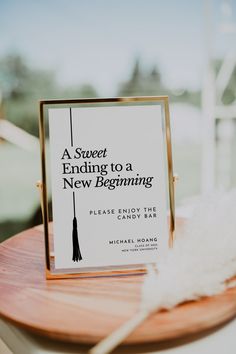 a book sitting on top of a wooden table next to a white feather and a sign