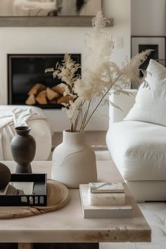 a living room with a white couch and table in front of a large fire place