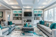 a living room filled with furniture and lots of windows in the wall mounted tvs