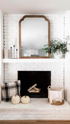 a living room with a fireplace, mirror and other items on the mantle in front of it