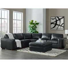 a living room with a sectional couch and ottoman