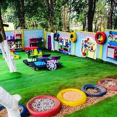 an outdoor play area with lots of toys on the grass and in front of it