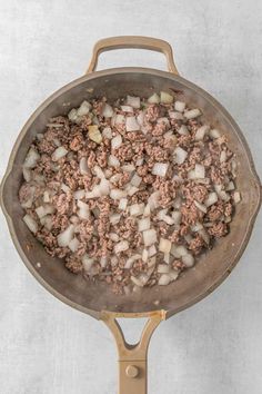 a pan filled with meat and onions on top of a stove