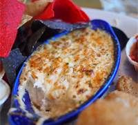 a blue dish filled with food on top of a table