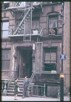 two people standing in front of an apartment building