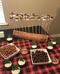 a table topped with chocolate covered pretzels and marshmallows on sticks