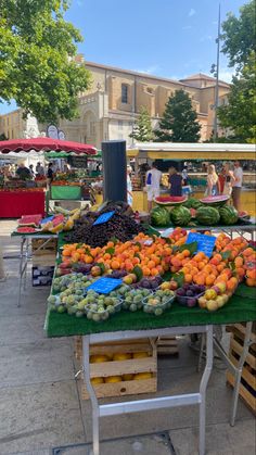 an outdoor market with fruits and vegetables for sale