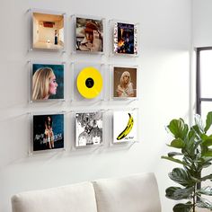 a white couch sitting next to a wall with pictures on it and a yellow frisbee