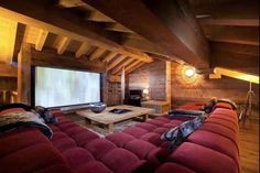 a living room filled with red couches and a flat screen tv mounted to the wall