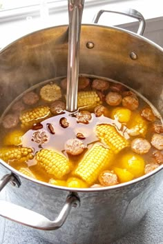 corn on the cob is being cooked in a pot with broth and spices