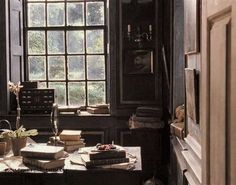 an old fashioned desk with books and a window