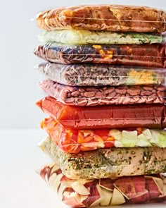 a stack of food wrapped in plastic sitting on top of a white table next to each other