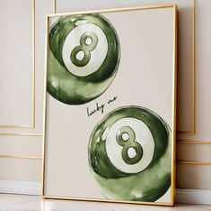 two green and white balls with the number eight on them in front of a wall