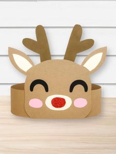 a cardboard reindeer head sitting on top of a wooden table