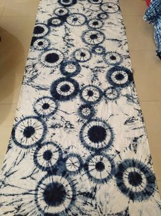 a black and white tie - dyed table runner with circles on it in a room