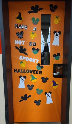 an orange door decorated with mickey mouse stickers and halloween decorations for the front door