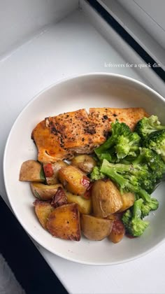 a white plate topped with chicken, potatoes and broccoli on top of a table