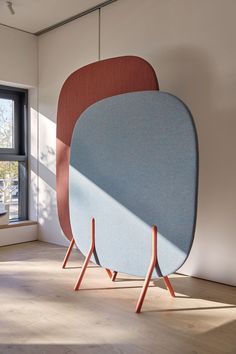 two chairs sitting next to each other on top of a hard wood floor in front of a window