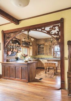 an old fashioned kitchen with wooden floors and cabinets in the center is seen from across the room