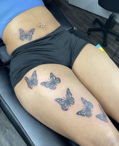 a woman laying on top of a chair with butterflies tattooed on her stomach and thighs