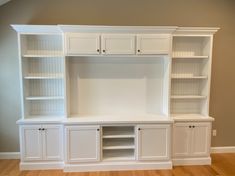 a white entertainment center with built in cabinets