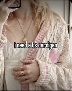 a woman holding a cell phone with the words i need it's cardigan