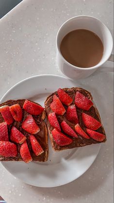 two pieces of toast with strawberries on them and a cup of coffee