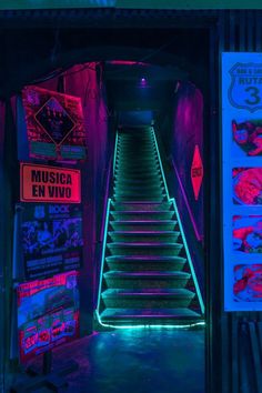 the stairs are lit up with neon lights in this dark tunnel that leads to an entrance