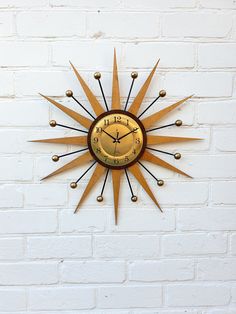 a clock mounted to the side of a white brick wall