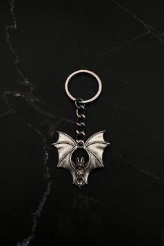 a metal key chain with a bat on it