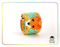 an orange, yellow and blue beaded bracelet on a white background with a penguin