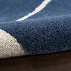 a blue and white rug on top of a wooden floor next to a brown table