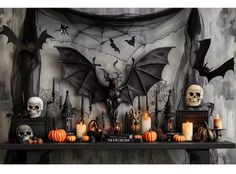 a halloween mantle with candles, skulls and bats on it in front of a wall