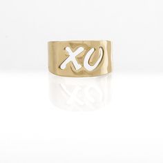 a gold ring with the letter x on it