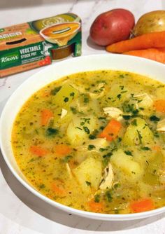 a bowl of soup with carrots, potatoes and apples next to some yogurt