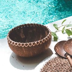 a bowl, spoons and mat next to a pool