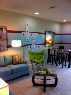 a living room filled with furniture and a crossword puzzle on the wall behind it