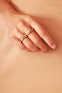 a woman's hand with a gold ring on her left side, and the other half of her stomach