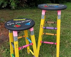 two colorful stools sitting in the grass with writing on them that say mr and mrs jonathan