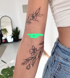 a woman's arm with tattoos on it and a green marker in the middle